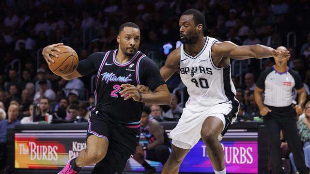 Miami Heat guard Norman Powell (24) dribbles around San Antonio Spurs forward Harrison Barnes (40) during the first half of the game on March 23, 2026, at Kaseya Center in Miami.